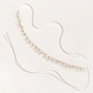 Détail d'un bandeau de mariée à fleurs 3D blanches avec fils dorés et rubans de satin