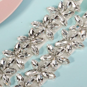 Detailed macro view of marquise rhinestone flower patterns on a white mesh ribbon trim