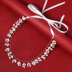 Serre-tête de mariée doré avec fleurs blanches et ruban satin sur fond rouge vif