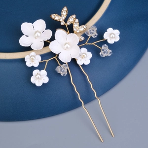 Détail de fleurs en céramique blanche et feuilles en cristal sur épingle à cheveux