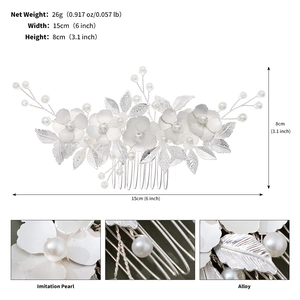 Détail d'un peigne de mariée argenté avec perles et feuilles métalliques, dimensions 15x8 cm