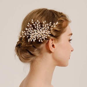 Detail of handmade gold wire hair comb with white pearls for elegant bridal hairstyles