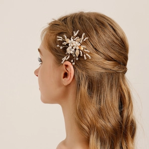Detail of handcrafted bridal hair clip with white pearls and crystals on blonde hair