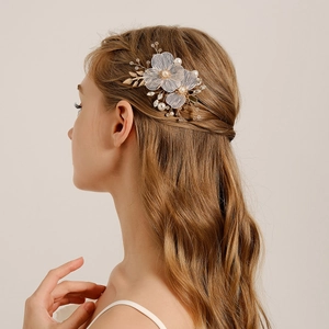 Detail of bridal hair clip with white tulle flowers and pearls for wedding