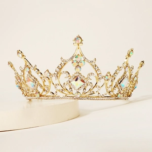 Detailed close-up of golden alloy crown with sparkling white and AB crystals in hollow design