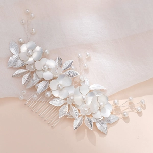 Détail d'un peigne de mariée fait main avec fleurs blanches et perles sur fil d'argent