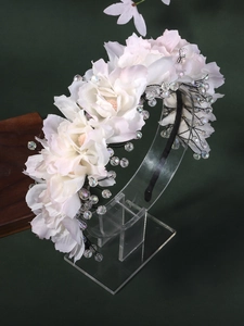 Close-up of handmade bridal headband with white fabric flowers and crystal beads