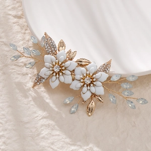 Macro detail of handmade bridal hair clip with white floral petals and blue gemstones