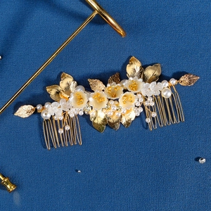 Detailed view of handmade gold bridal hair comb with pearls and white floral petals
