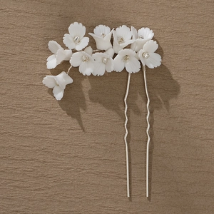 Détail du pic à cheveux argenté avec fleurs en céramique blanche mate et strass brillants