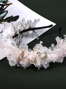 Detail of pink fabric flowers and crystal beads on a handmade floral headband