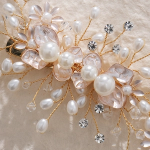 Detail of handmade bridal hair clip with white pearls, pink petals and gold wire art