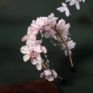 Détail du serre-tête floral fait main avec fleurs en soie rose et fil doré en perles