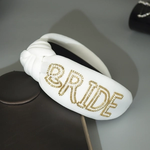 Detailansicht des weißen Brauthaarreifens mit handgestickten BRIDE Perlen und Perlenstickerei