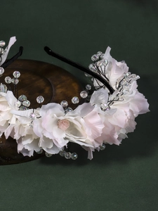 Detail of floral headband with white fabric petals and transparent crystal beads