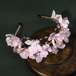 Vue détaillée des fleurs en tissu rose faites à la main et perles de cristal sur le bandeau