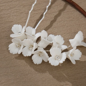 Détail d'une épingle à cheveux en fleur de céramique blanche faite à la main et perles
