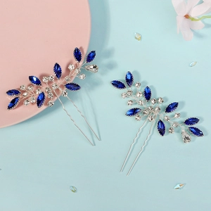 Détail de pics à cheveux de mariée faits main avec pierres bleues et design de feuilles