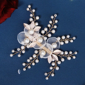 Detail view of handmade bridal hairband with pearls, gauze flowers and gold leaves
