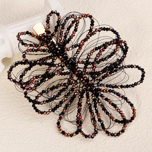 Handmade black beaded flower hair clip with crystal accents and gold-tone metal base