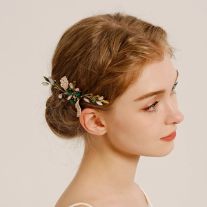 Détail de peigne à cheveux mariée avec cristaux verts et feuilles blanches sur modèle