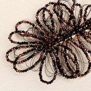 Detail of handmade black crystal beaded floral hair clip with iridescent faceted beads