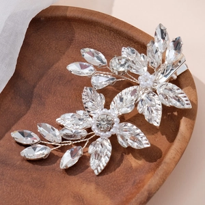 Handmade bridal hair clip with silver leaves, crystal flowers and pearls on wood tray