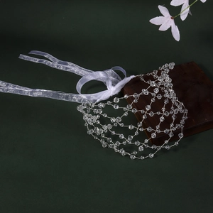 Close-up of handmade crystal mesh bridal headband with white satin ribbons on wood