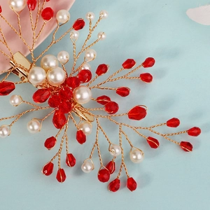 Dettaglio di fermaglio per capelli da sposa con cristalli rossi e perle bianche