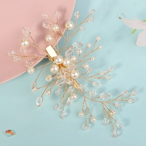 Dettaglio di fermaglio per capelli da sposa con filo dorato, perle e cristalli su rosa