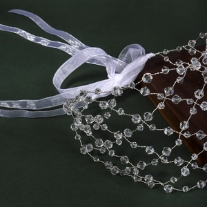 Macro detail of handmade crystal beaded bridal hair net with intricate silver mesh and ribbons