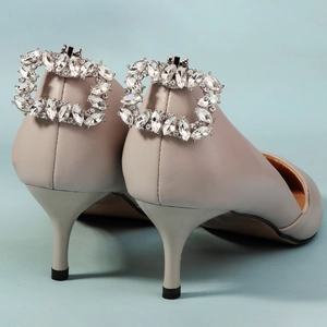 Detailaufnahme eines High Heels mit einer großen, funkelnden Strass-Quadratschnalle