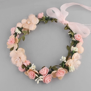 Close-up of handmade floral headband with pink fabric roses and adjustable ribbon bow