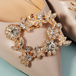 Nahaufnahme der luxuriösen Strass-Schuhschnalle mit Blattmuster auf beigem Pumps