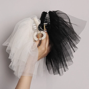 Détail de pinces à cheveux élégantes avec nœuds en résille noir et blanc et ressort