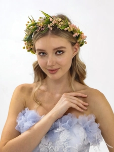 Detail of pink floral bridal crown with green leaves on model for a romantic wedding look