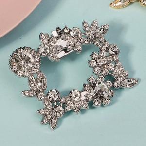 Makro-Detail eines silbernen Schuhclips mit funkelndem Strass-Blumendesign