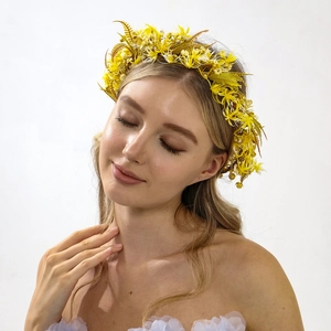 Detail of bridal floral headband with yellow fabric flowers and feather-like leaf accents