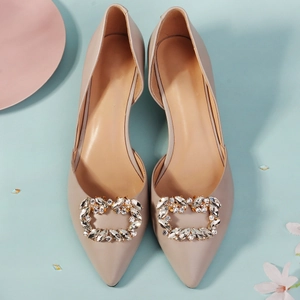 Detailansicht von spitzen Pumps mit funkelnden herzförmigen Strass-Schnallen von oben