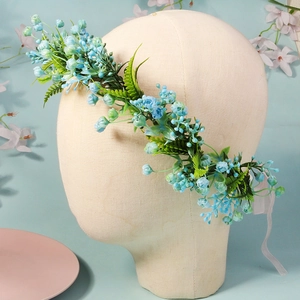 Detail showing blue floral bridal hair wreath with green fern leaves and white silk ribbon