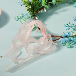 Detailed close-up of light blue floral crown with soft pink organza ribbon tie