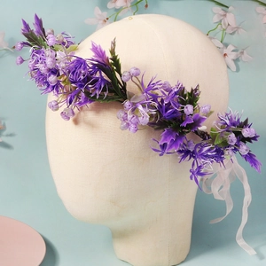 Close-up of purple star flowers and green leaves on a bridal flower crown hairpiece