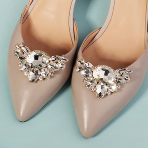 Nahaufnahme der funkelnden Kristall-Schuhclips auf beigen spitzen Pumps für Bräute