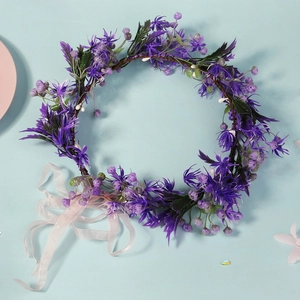 Detail of purple bridal floral wreath with lifelike petals, berries and long silk ribbons