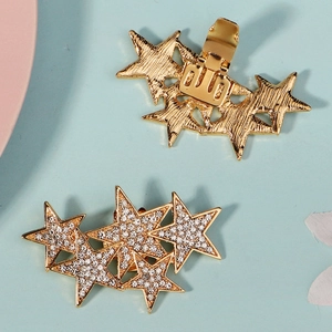 Detailansicht der goldenen Stern-Haarspangen mit Strasssteinen und Metallfederclip