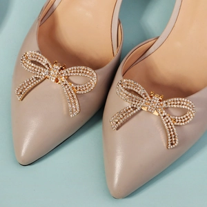 Detail von abnehmbaren goldenen Schuhclips mit Kristallen auf spitzen High Heels