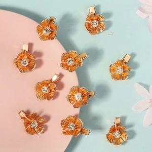 Detailed macro view of golden metal flower hair clips with sparkling crystal centers
