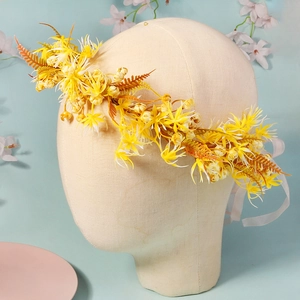 Detailed view of yellow faux flower crown headpiece with delicate white ribbons