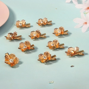 Detailed macro view of gold metal flower hair clips with sparkling center crystal rhinestones