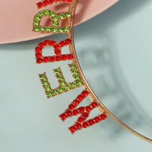 Détail de gros plan du serre-tête Merry Christmas doré avec strass rouges et verts